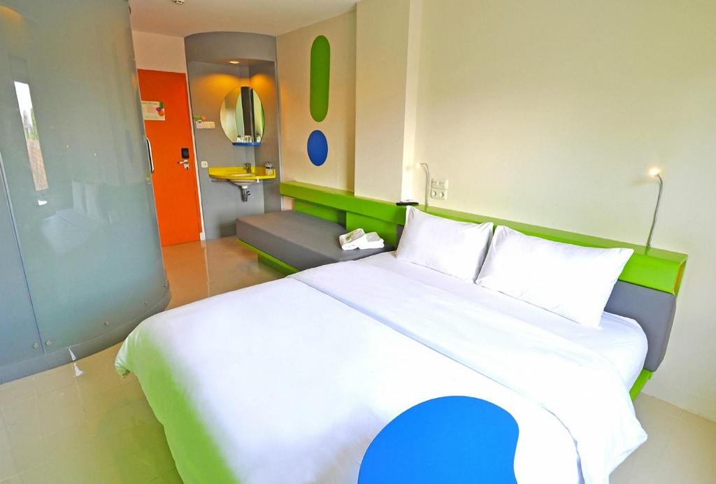 当格浪POP!雅加达机场酒店的一间带大床的卧室和一间带沙发的房间