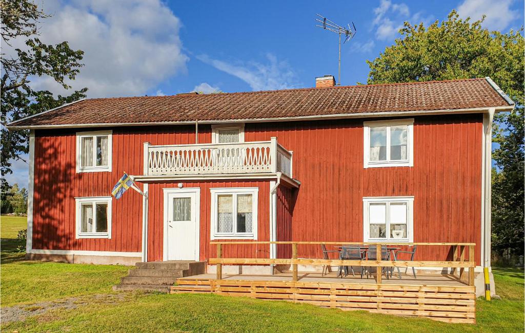 韦特兰达Amazing Home In Vetlanda With Wifi的一间红色的房子,前面有一个大甲板