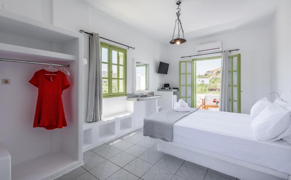 阿波罗尼亚Pente Elies Milos的一间白色卧室,配有床和衣架上的红色连衣裙