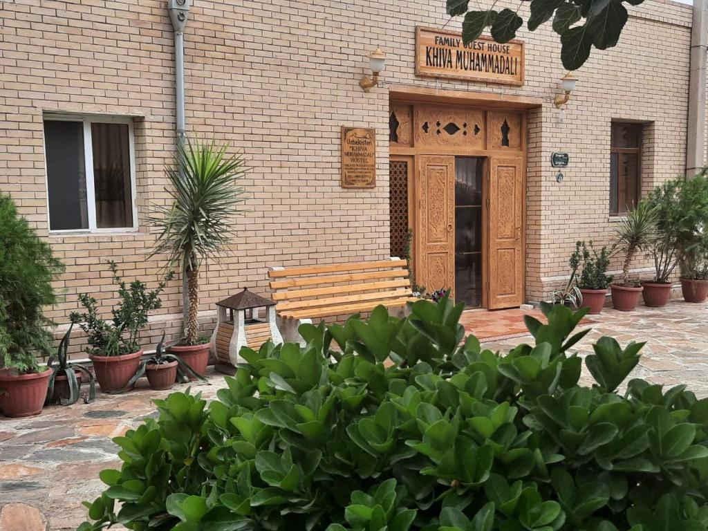 希瓦Khiva Muhammadali的坐在大楼前的木凳