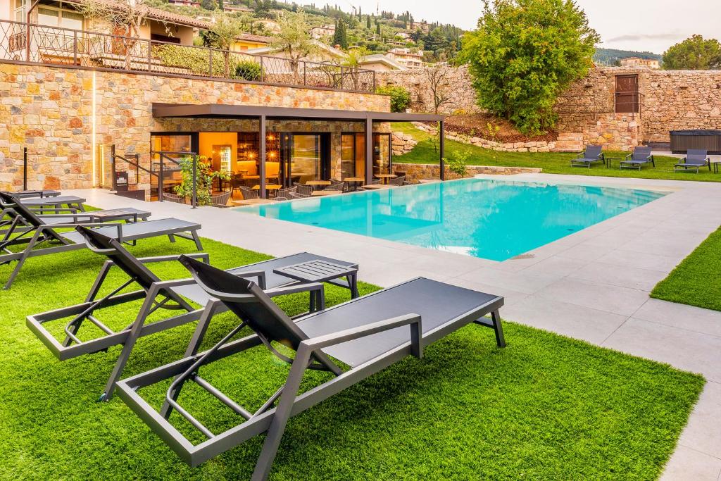 托里德尔贝纳科Relais Limonaia - Suites & Garden SPA的别墅 - 带带椅子的游泳池和庭院