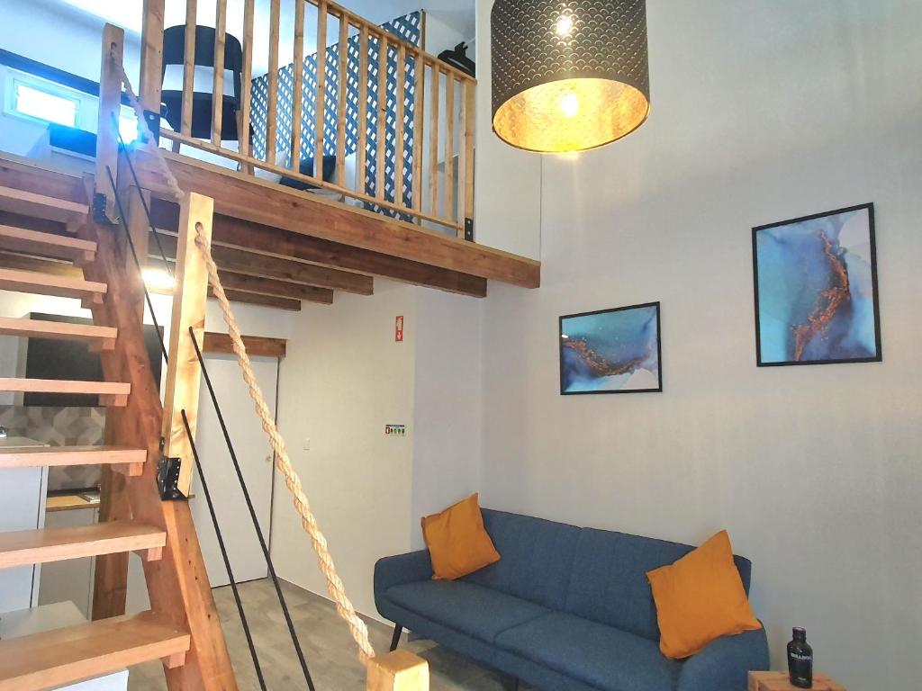 蒙塔吉尔Xagi House - Montargil的客厅设有蓝色的沙发和楼梯。