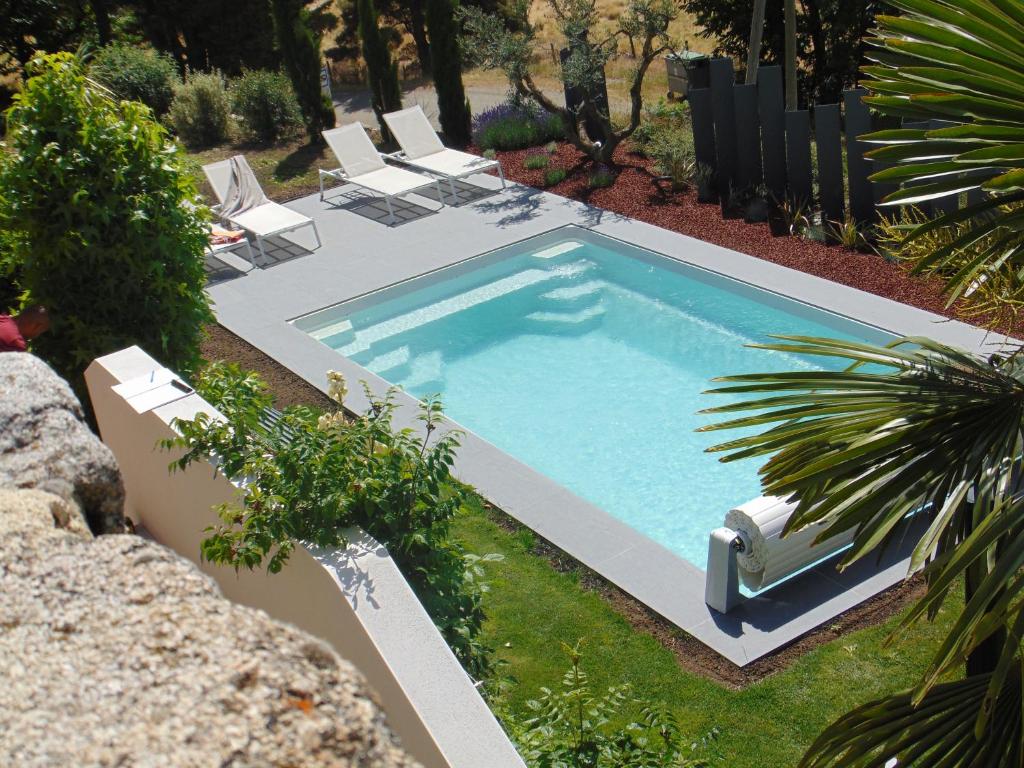 GluirasMaison d'Hotes Les Palmiers的一个带躺椅的庭院内的游泳池