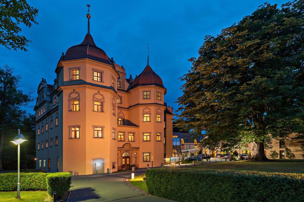 Bertsdorf阿申瑞尼兹斯加罗酒店的一座大建筑,塔上装有钟