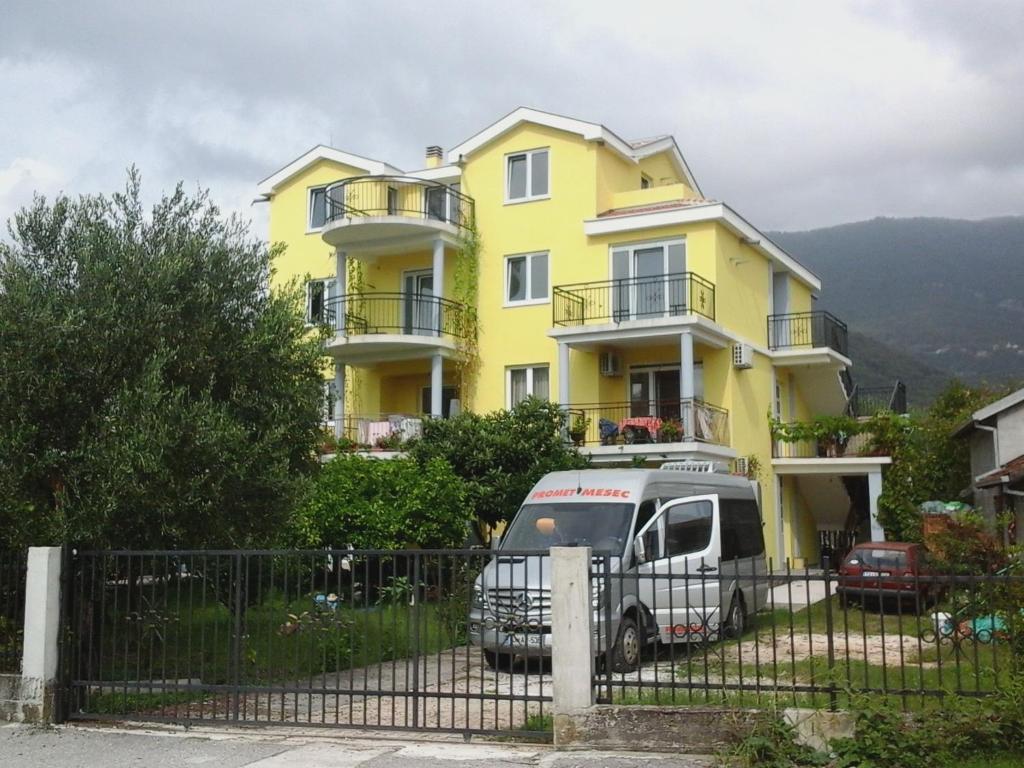 蒂瓦特Apartments Olga的停在黄色房子前面的卡车