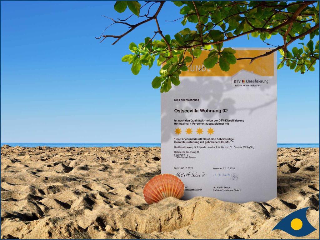 赛巴特班森Ostseevilla Whg 02的沙滩上的标志,沙子上有一枚贝壳
