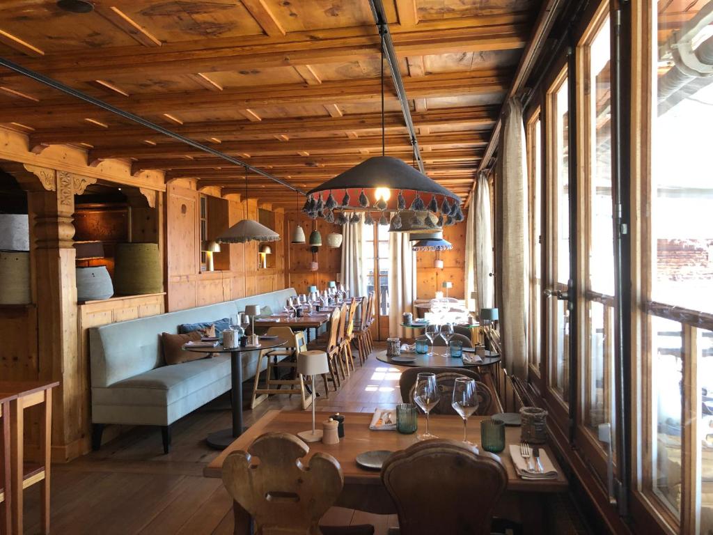 圣吕克法夫雷木屋大酒店的餐厅设有木制天花板和桌椅