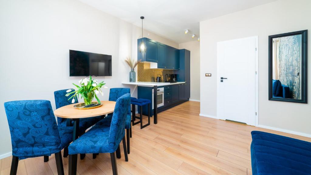 耶莱尼亚古拉HELLO Apartamenty Evo - Długa 15的一间配备有蓝色椅子和桌子的用餐室