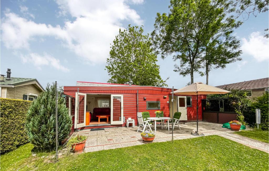 曲马勒姆Amazing Home In Tzummarum With Outdoor Swimming Pool的院子里的一栋红色小房子,带有庭院