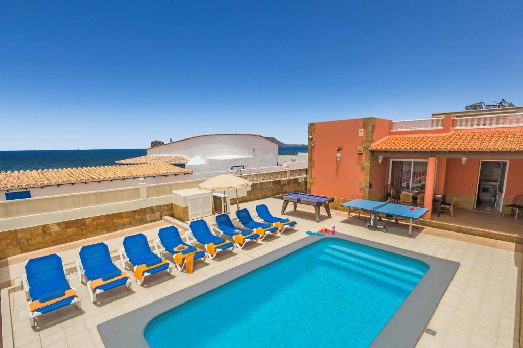拉奥利瓦Villa Tamarindos by Villa Plus的一个带躺椅的游泳池和海洋