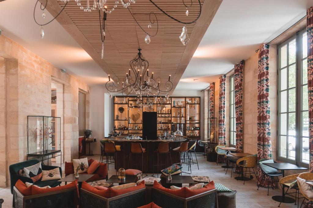 波尔多Hotel La Zoologie & Spa Bordeaux的带沙发的大堂和位于中间的酒吧