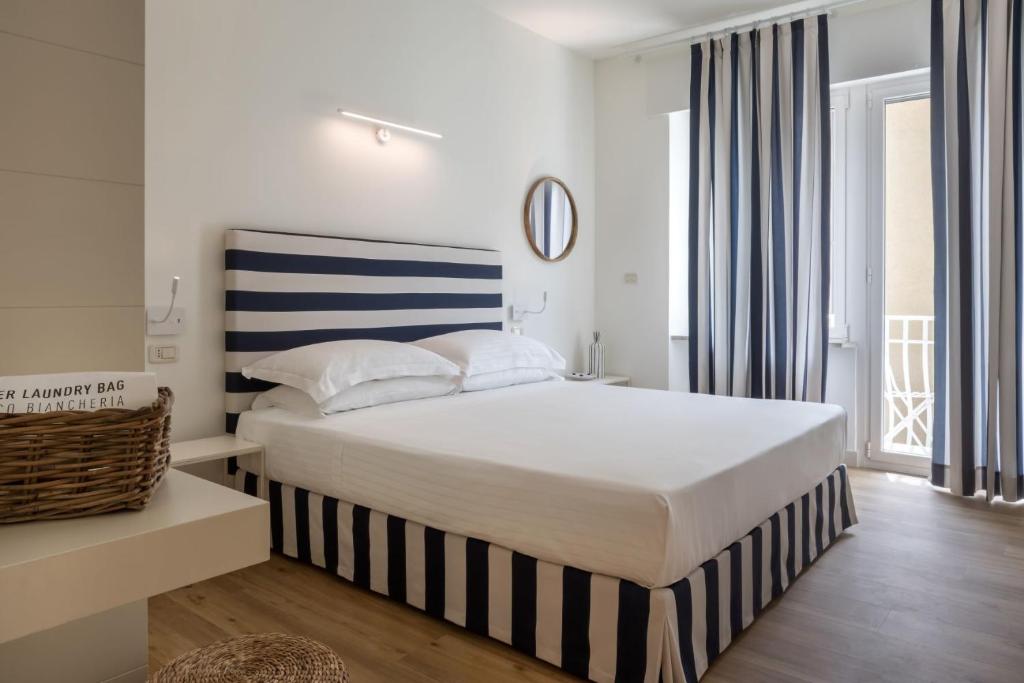 努马纳Murè Hotel Numana的一间卧室配有一张带蓝白条纹床头板的床