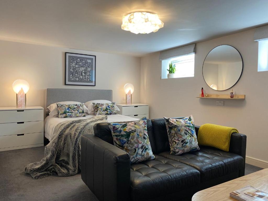大雅茅斯Jays Bay Entire Luxury Apartment by the Beach Gt Yarmouth的一间卧室配有一张床、一张沙发和一面镜子