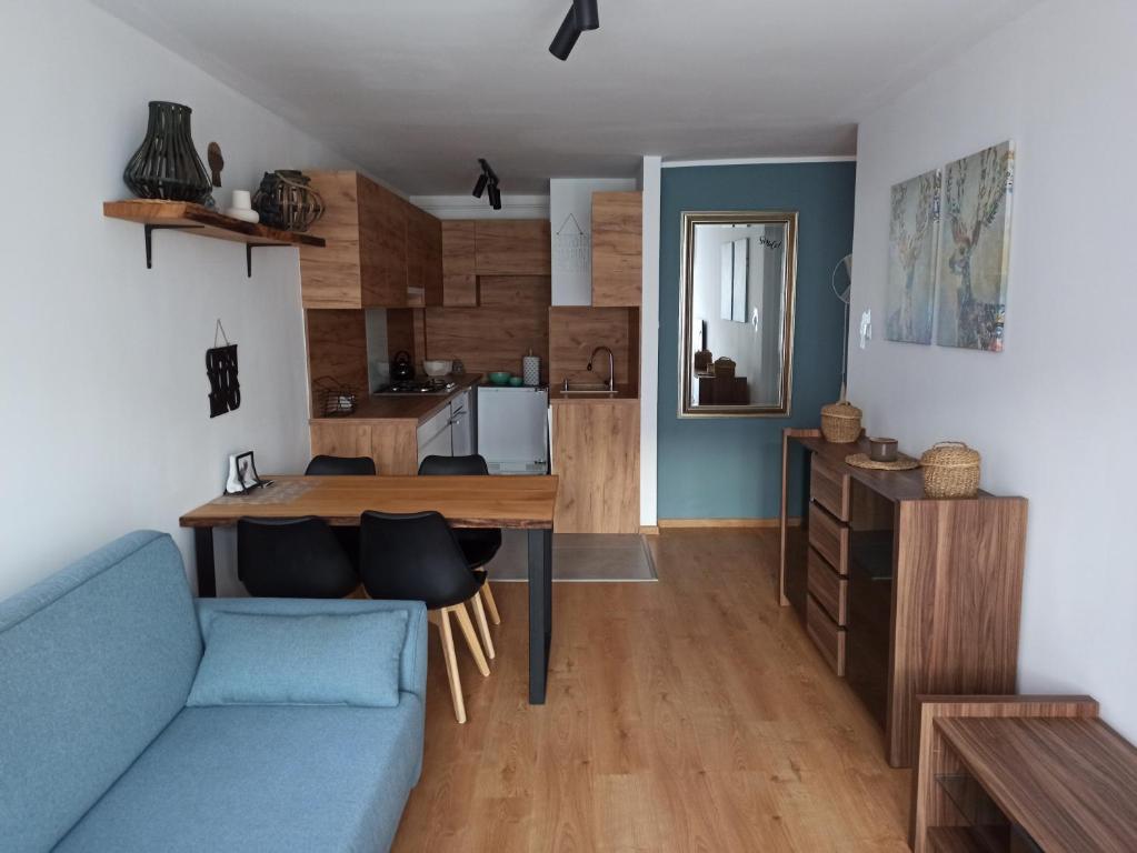格但斯克Uroczy apartament nad morzem Gdańsk的客厅配有蓝色的沙发和桌子