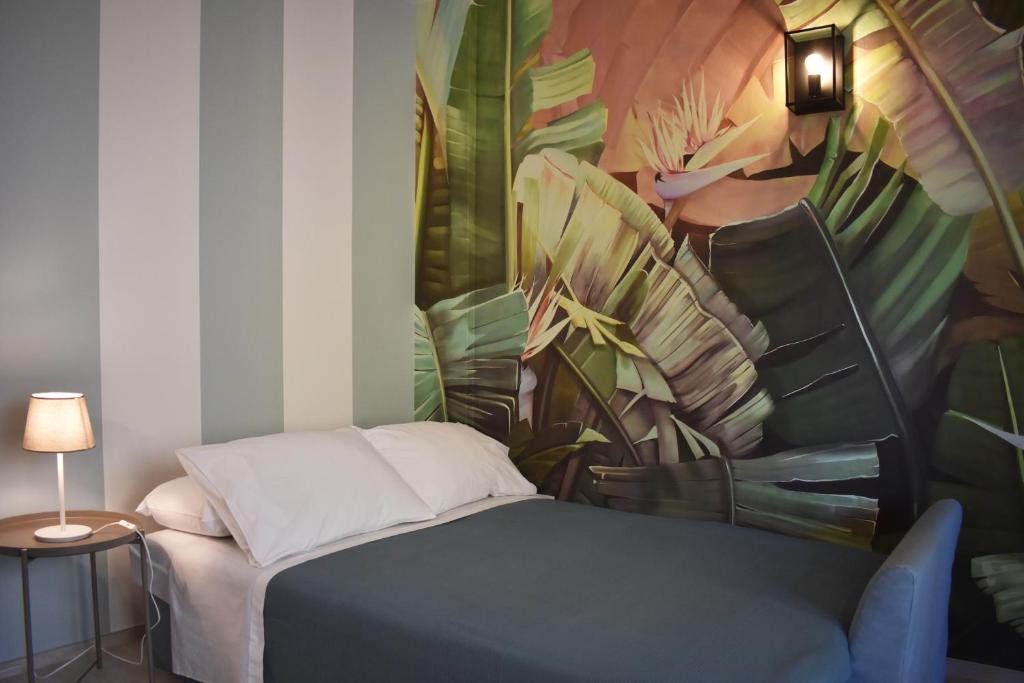 努马纳Le Quiete Stanze, vacancy houses posto spiaggia in omaggio的一间卧室配有一张壁画床