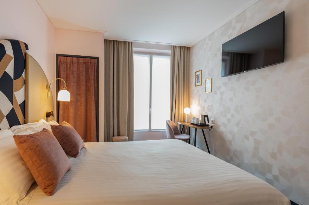 巴黎皇家圣日耳曼酒店的酒店客房设有一张大床和一台电视。