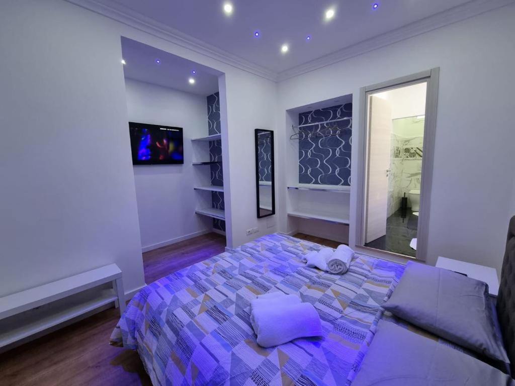 圣雷莫Piazza Colombo-Apartments的一间卧室配有一张带紫色床单和镜子的床