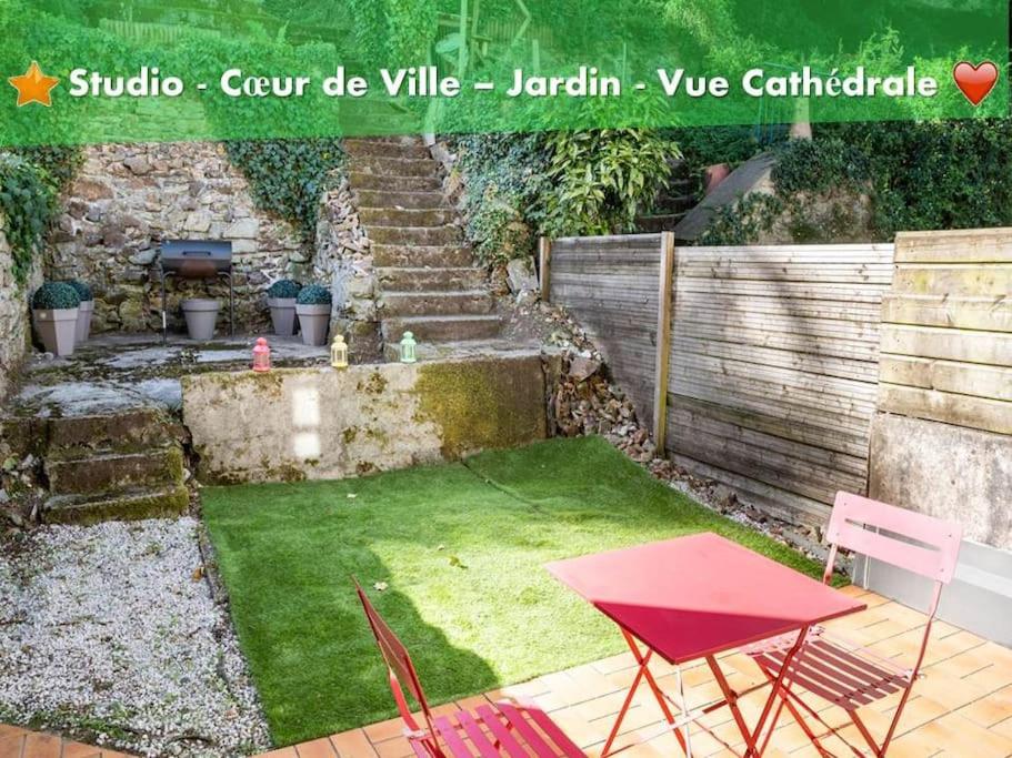 坎佩尔oo Le jardin oo paisible studio équipé et bien placé的一个带红色桌子和椅子的小花园