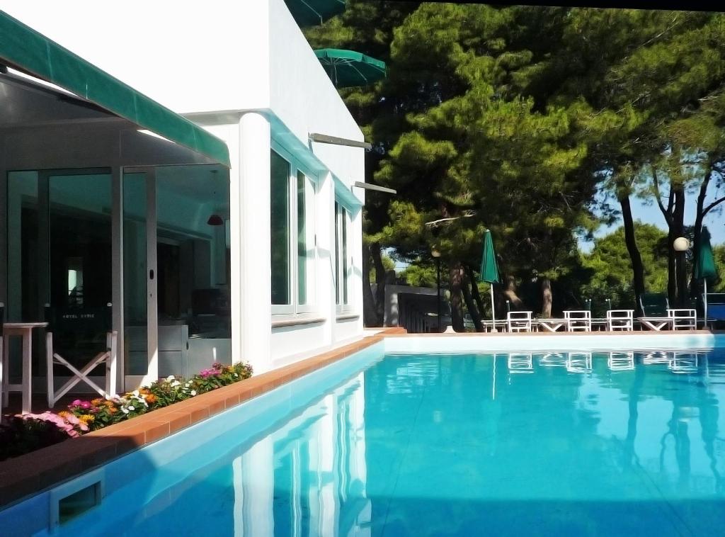 圣多米诺凯里伊索莱特雷米蒂酒店的房屋旁的游泳池