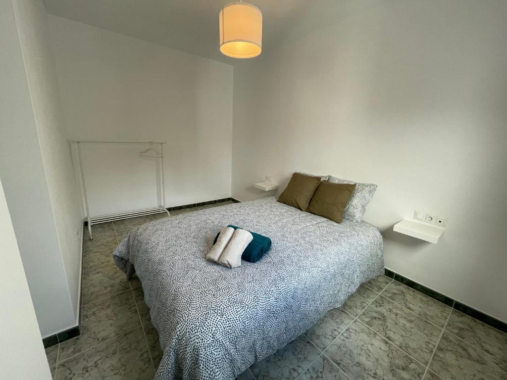 托洛克斯Apartamentos Los Senderos de Tolox的一间卧室配有一张带枕头的床