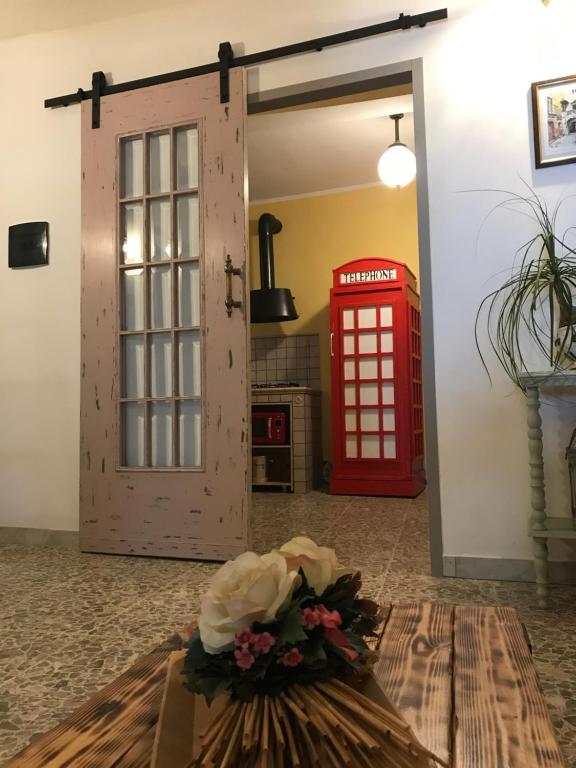 蒙泰圣比亚焦Alloggio per turisti a solo 10 minuti dal mare的红门旁边的红色电话亭和花瓶