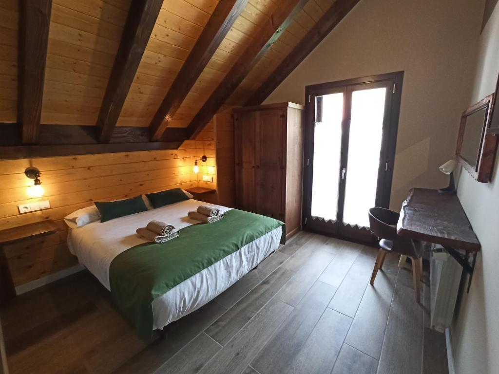 伊萨瓦Casa rural ELURKOIA的一间卧室配有一张床、一张书桌和一个窗户。
