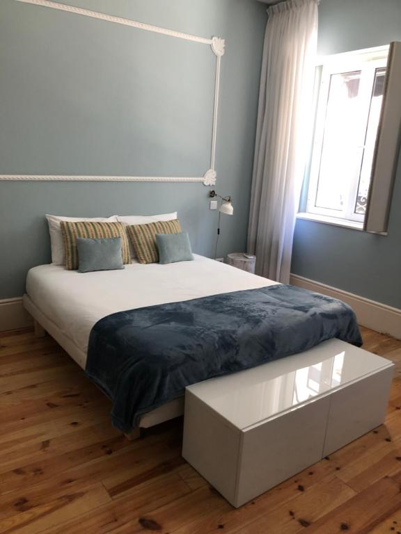 马托西纽什Godinho's House的一间卧室设有一张大床和一个窗户。