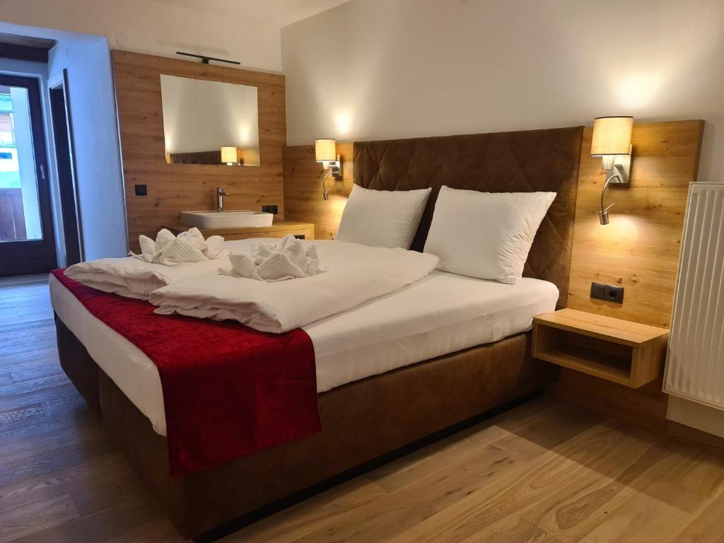卡顿巴赫Hotel Alpenhof***的酒店客房设有一张大床和一个水槽