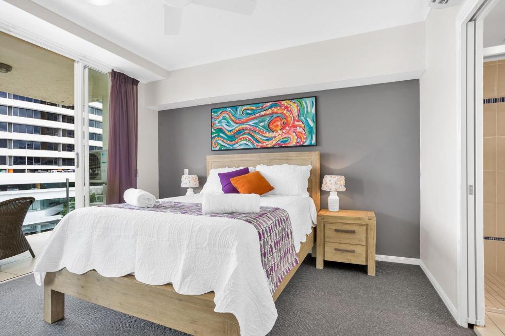 凯恩斯City Quays Luxury Dual Key的卧室配有一张床,墙上挂有绘画作品