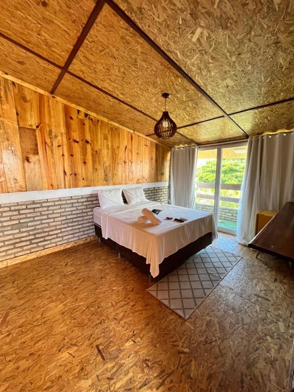 弗雷谢拉斯Villa Flecheiras的卧室配有一张床铺,位于带木墙的房间内