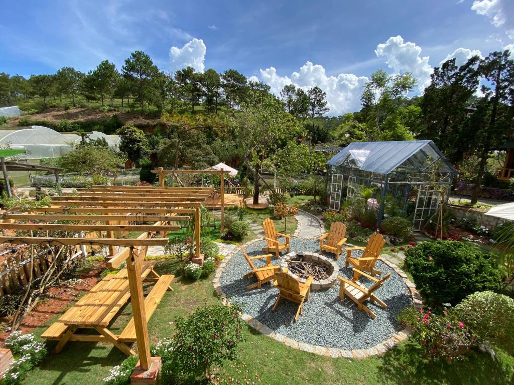 大叻贝瑞瓦利山林小屋的花园设有木长椅和桌椅