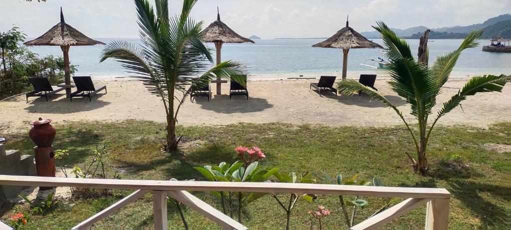 Gili GedeAlam Karang的享有带椅子和遮阳伞的海滩美景