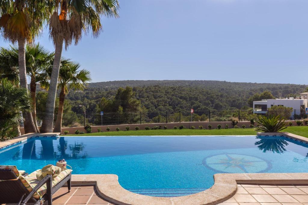 Sol de MallorcaLuxurious villa Sol de Mallorca的一座棕榈树环绕的大型游泳池