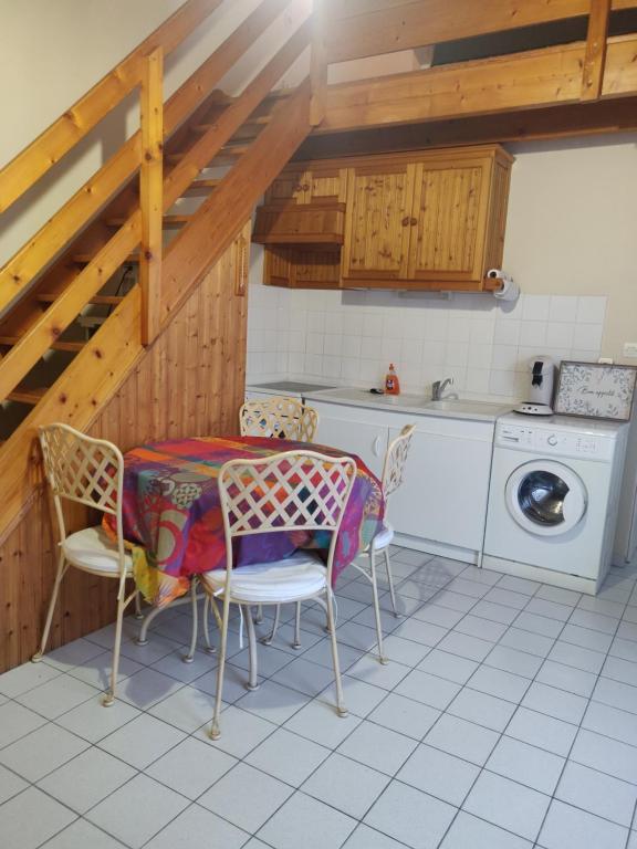 莱萨布勒-多洛讷Maison au Coeur des Sables d'Olonne的厨房配有桌椅和洗衣机。