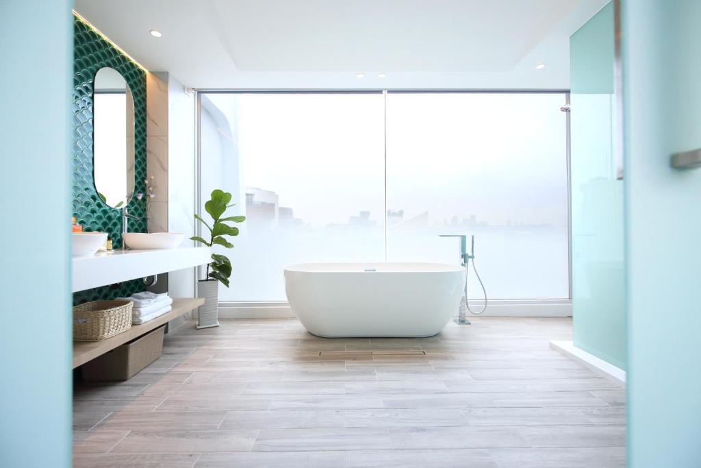 花莲市椛堤VILLA的带浴缸的浴室和大窗户
