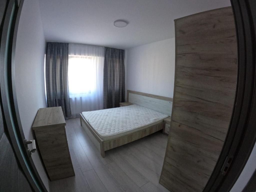 拉姆尼库沃尔恰Cazare bloc nou ultracentral的一间小卧室,配有床和窗户