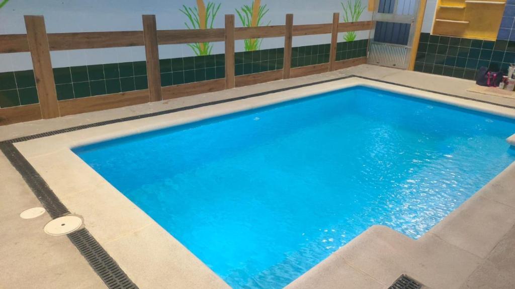 Vega de Santa MaríaCasa Rural Baños de la Reina con piscina climatizada的一个带木栅栏的大型蓝色游泳池