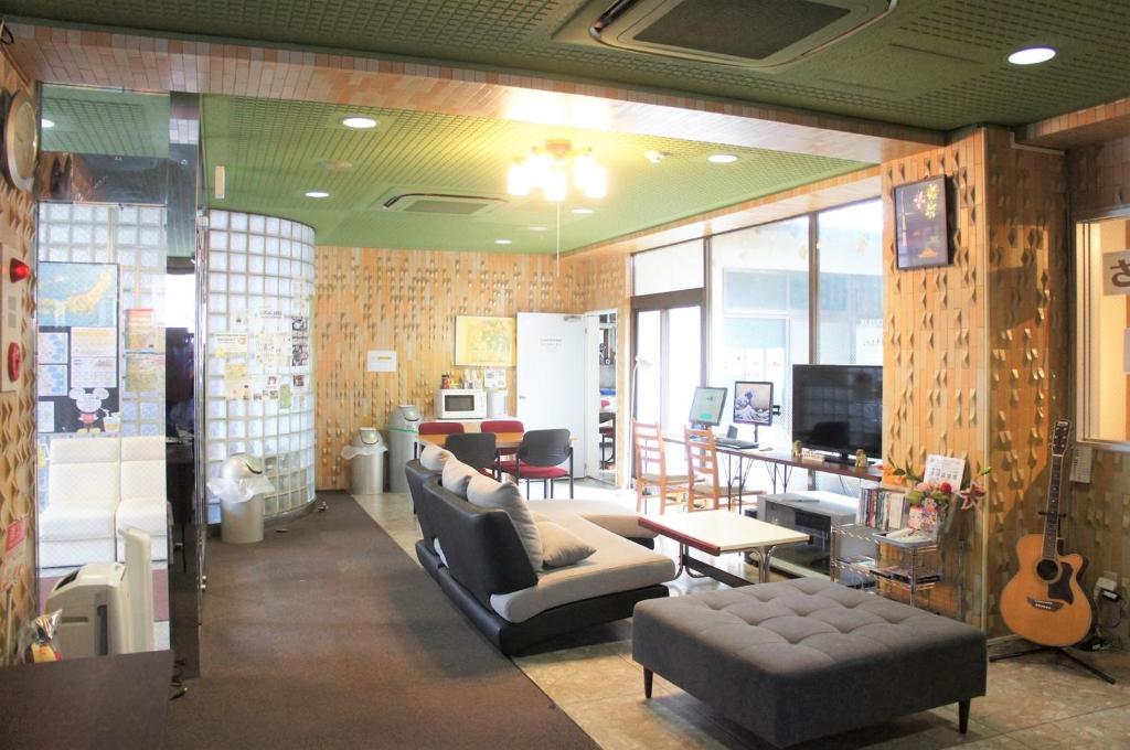 东京加优酒店的客厅配有沙发、椅子和电视