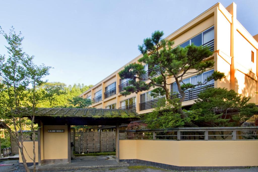 日光日光星之宿酒店(Nikko Hoshino Yado)的公寓大楼前面有一棵树