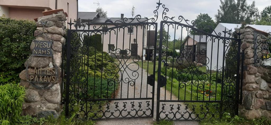 Straupeviesu nams "Laimes pakavs"的通往带花园的房屋的大门