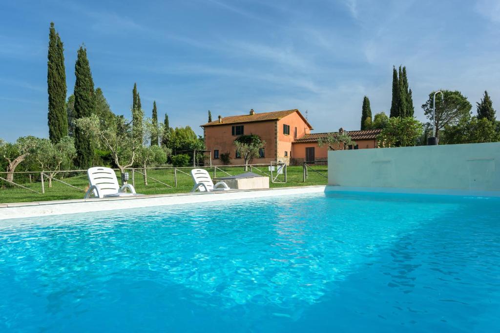 BurianoAgriturismo Zuccherini的一个带椅子的游泳池以及一座房子