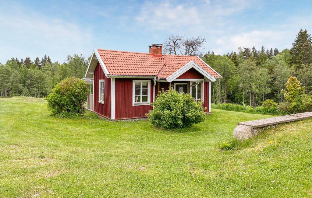 Stunning Home In Tranhult With Kitchen的绿色田野上的一座红色小房子