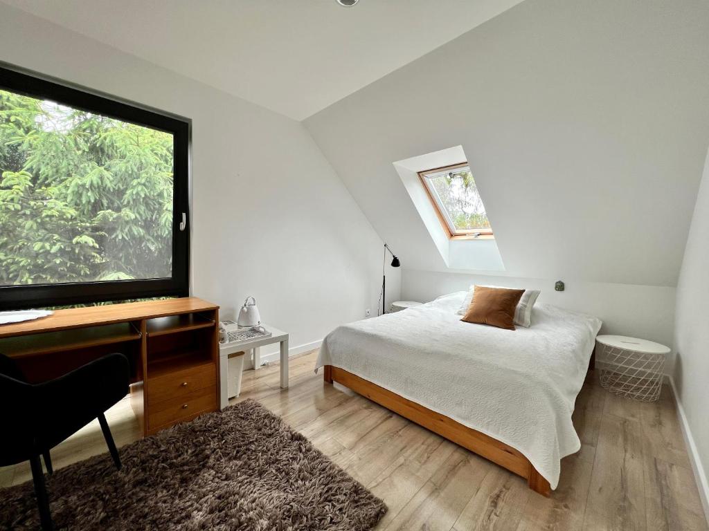 米科泽沃Garden Room的一间卧室配有一张床、一张书桌和一个窗户。