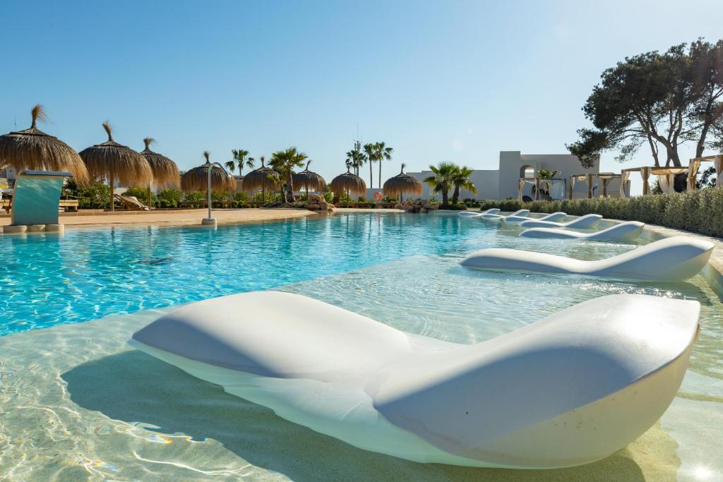 卡拉达沃Eques Petit Resort的水中带白色椅子的游泳池
