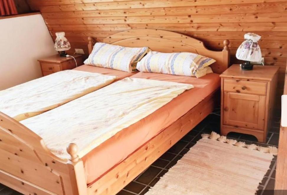 索嫩比赫尔Doppelzimmer Waldblick的木墙客房内的木床