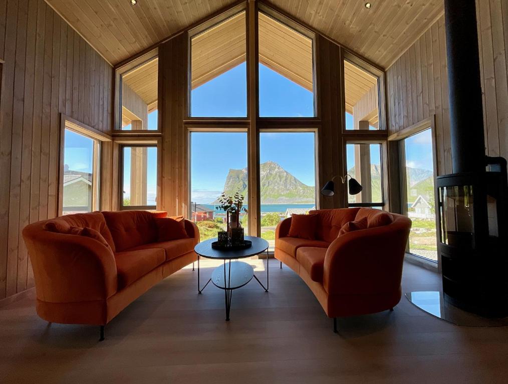 莱克内斯Haukland Beach View - Superior cabin的客厅配有2张橙色沙发和1张桌子