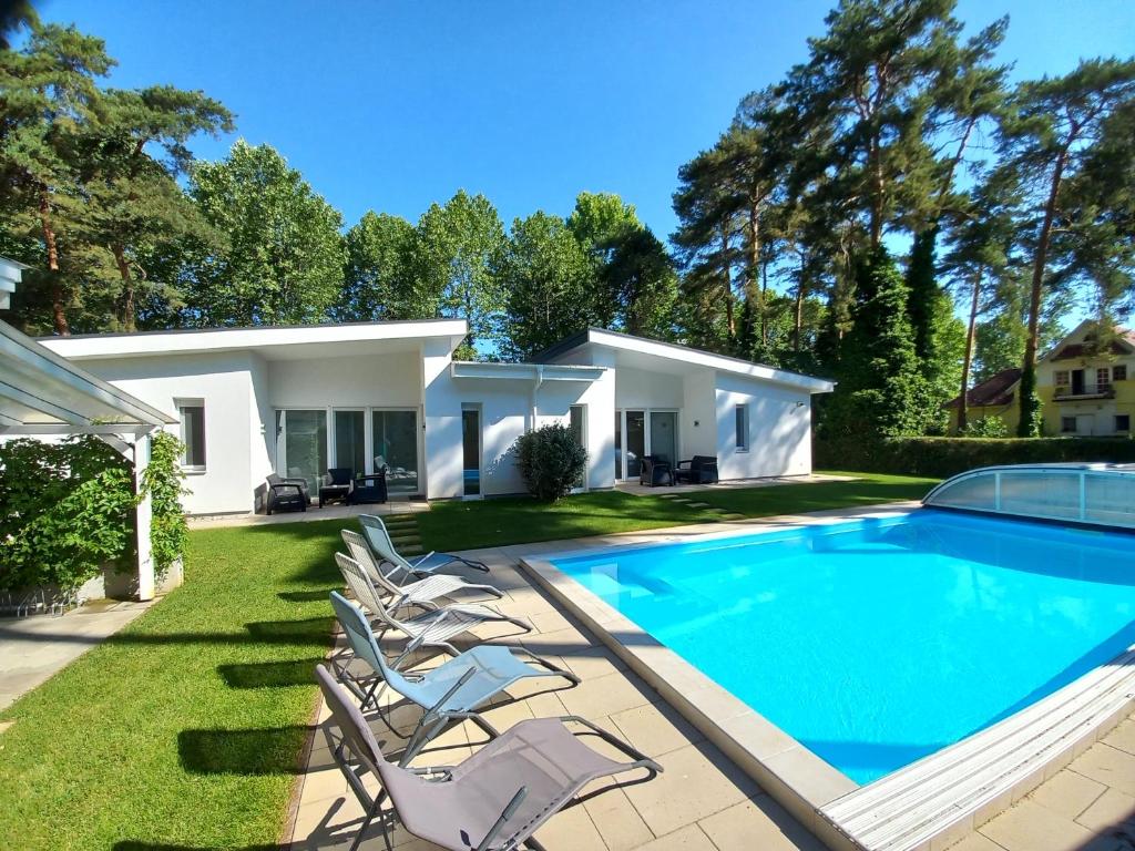 希欧福克Villa Bori Siófok的一座带游泳池和躺椅的房屋