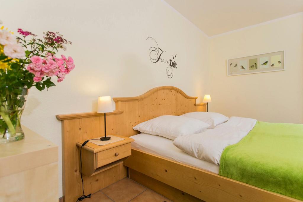 巴德贝芬森Landhaus Teuteberg的一间卧室,配有一张床和花瓶