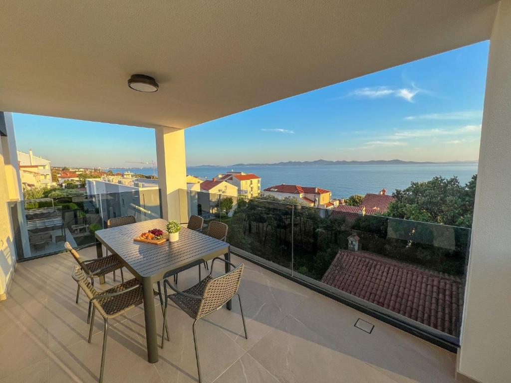 科济诺Zadar Premium Apartments的海景阳台上的桌椅