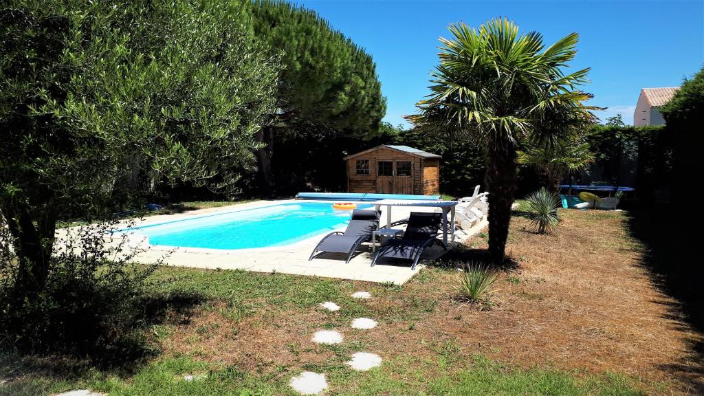沙特拉永普拉日Gîte 3 étoiles 300m plage piscine privée grand jardin的一个带躺椅的游泳池以及一座房子